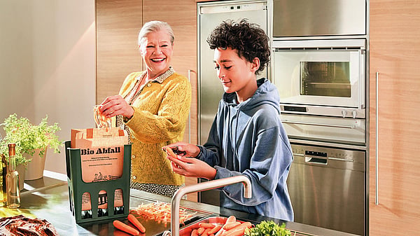 An older lady and a young boy in a kitchen preparing food whilst surrounded by Mondi's Advantage MF EcoComp packaging.